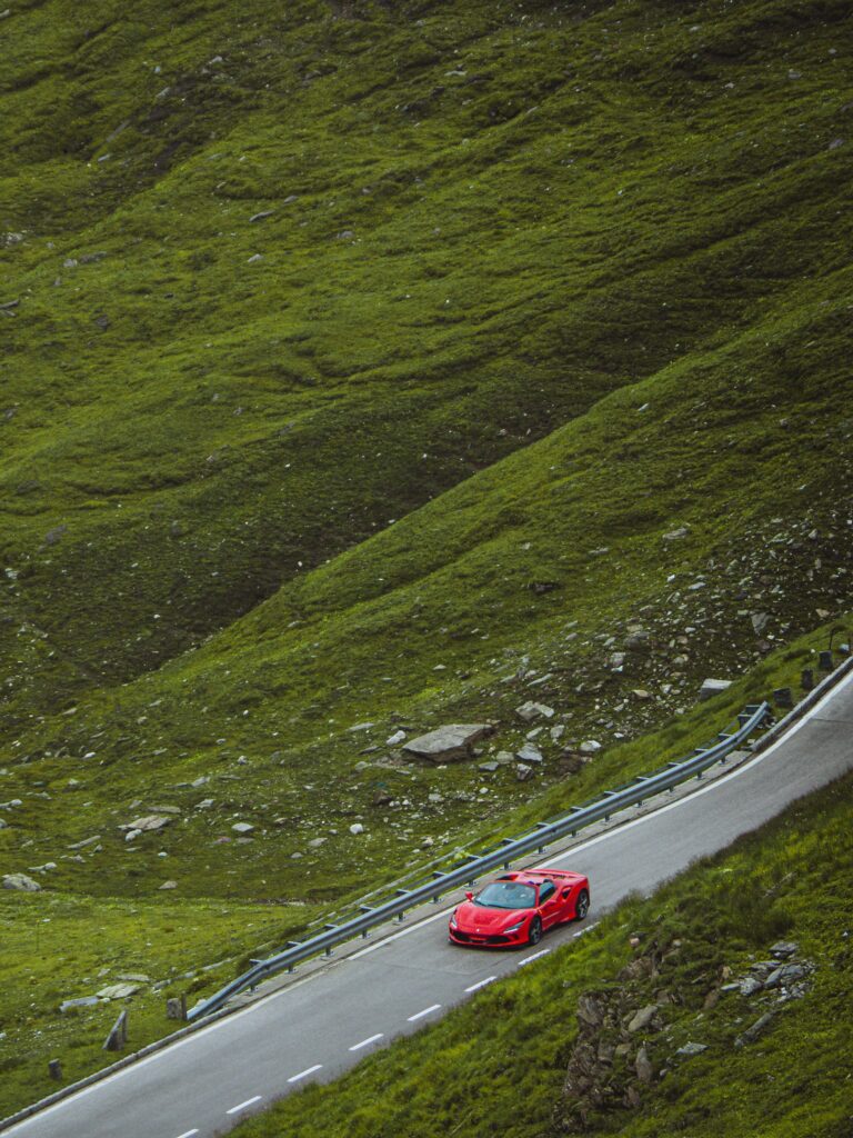 Red sports car on an open country road Red sports car on an open country road