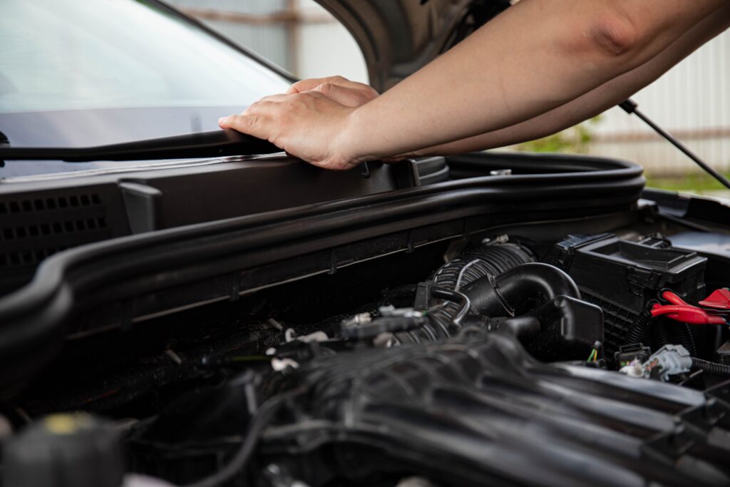 Technician inspecting a car engine bay Technician inspecting a car engine bay