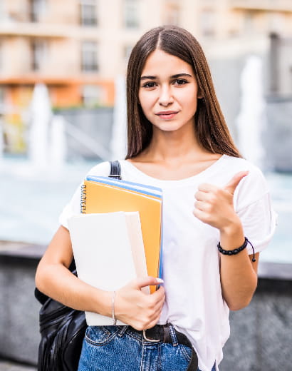 happy-student-girl-posing-with-thumbs-up-looking-you-street